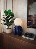 Lampe de table Maren en céramique bleu marine avec globe en verre opalin blanc